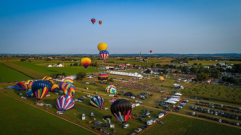 Bird in Hand, Pennsylvania: Drone View of a Hot air Balloon Festival With Many Balloons Floating Thru Farmlands on a Summer Day