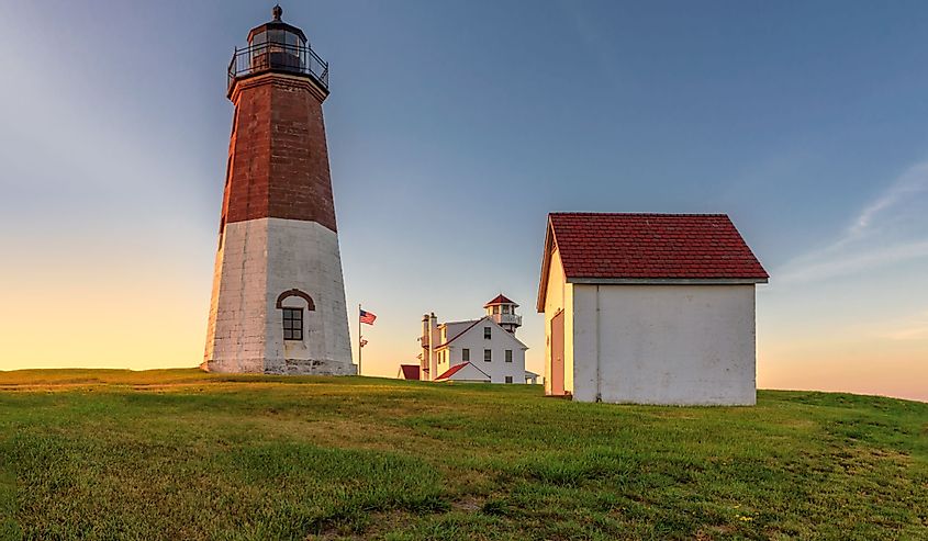 The Point Judith light near Narragansett, Rhode Island, against a bright sunset.