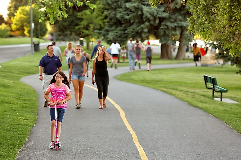 Families, couples, and individuals recreating on a public greenbelt path in Idaho Falls, Idaho