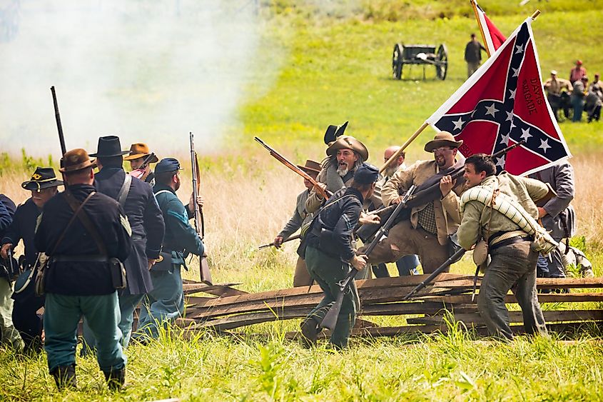 Confederate soldiers breach a Union barricade during a US Civil War reenactment.