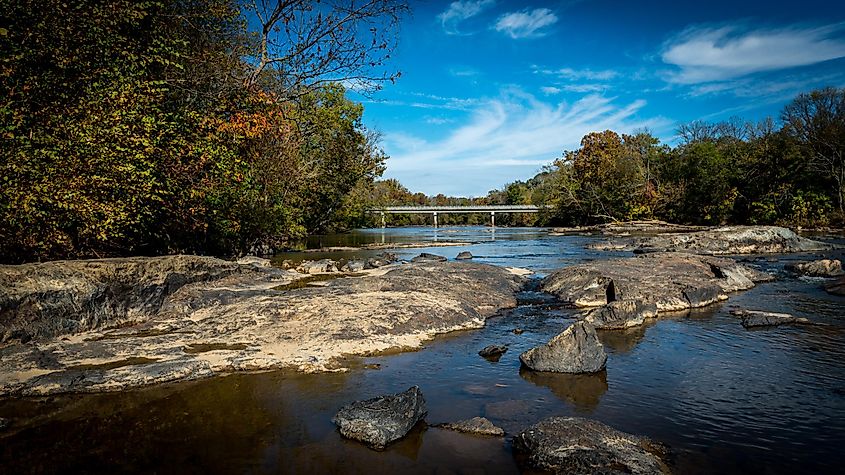 Haw River at Swepsonvile River Park with early foliage and bridge in the background.