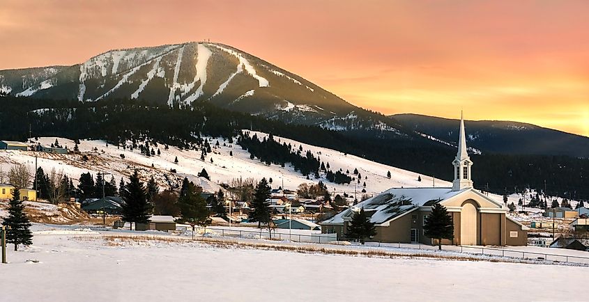 Discovery Ski area on Rumsey Mountain and Philipsburg community church in Philipsburg, Montana at sunset