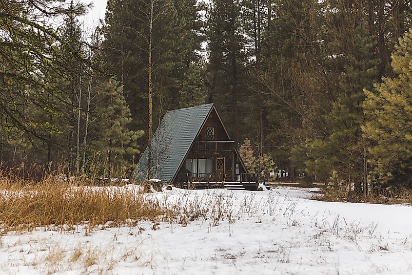 A-frame cabin building nestled in a thick forest area in Featherville, Idaho, USA.