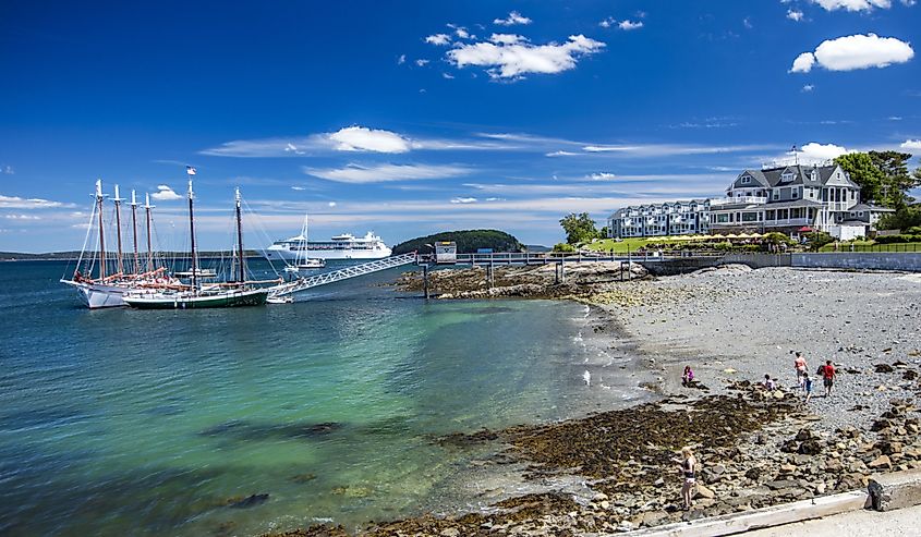 Boats in the water and people on the shore at Bar Harbor shore front in Maine