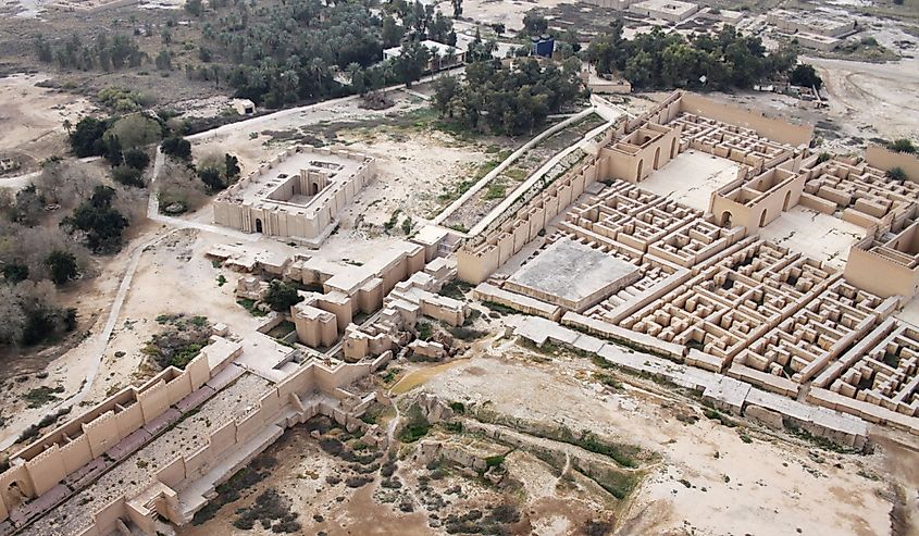 Restored ruins of the South palace of Nebuchadnezzar in ancient Babylon, Iraq on the right. Ruins of the North palace damaged by US occupation on the left. Beyond Processional Street is Ninmah temple