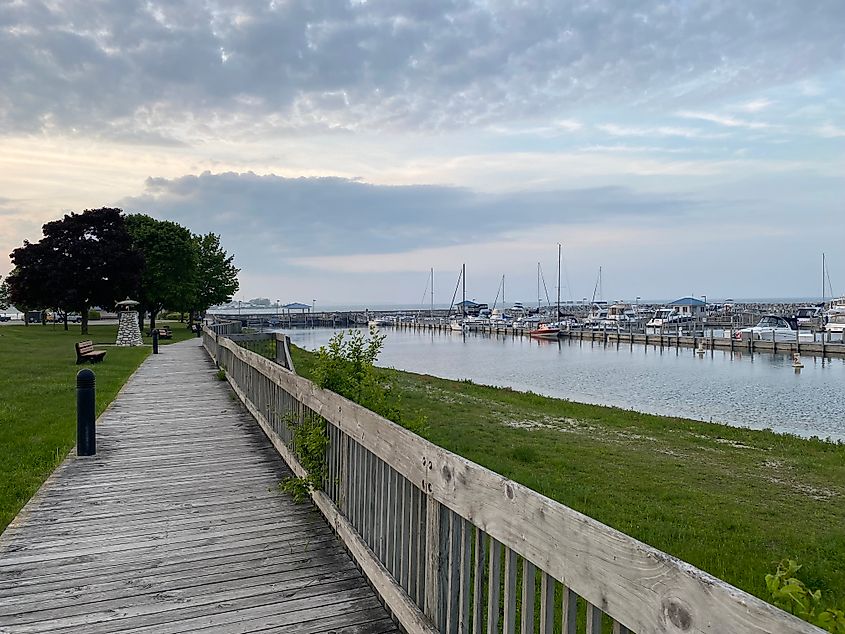 A wooden boardwalk parallels a marina.