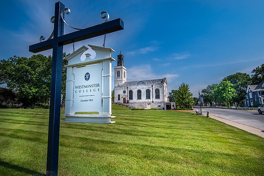 Fulton, MO--June 26, 2020; Sign hangs from post marking location of Westminster College with National Winston Churchill Museum and monument in the background