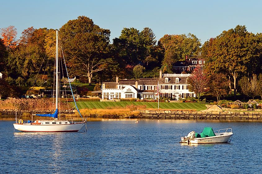 A sailboat is moored in front of a luxury waterfront estate in Greenwich, Connecticut. 