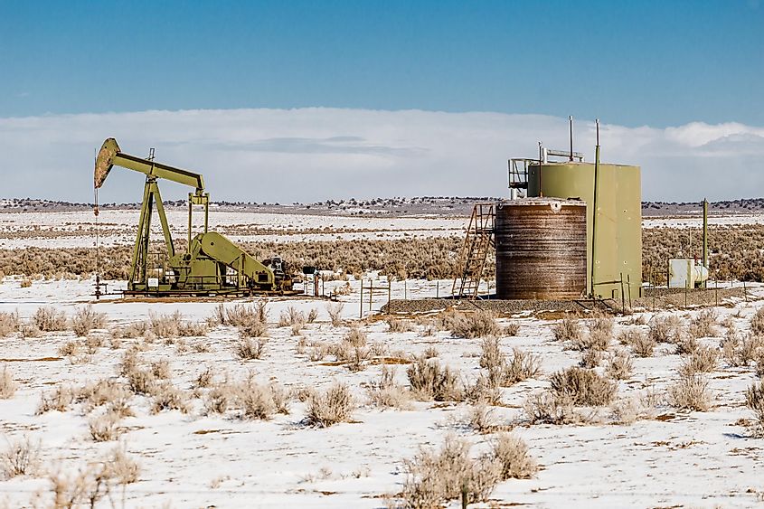 onely oil pump in the middle of a snow covered desert landscape on clear day in rural New Mexico