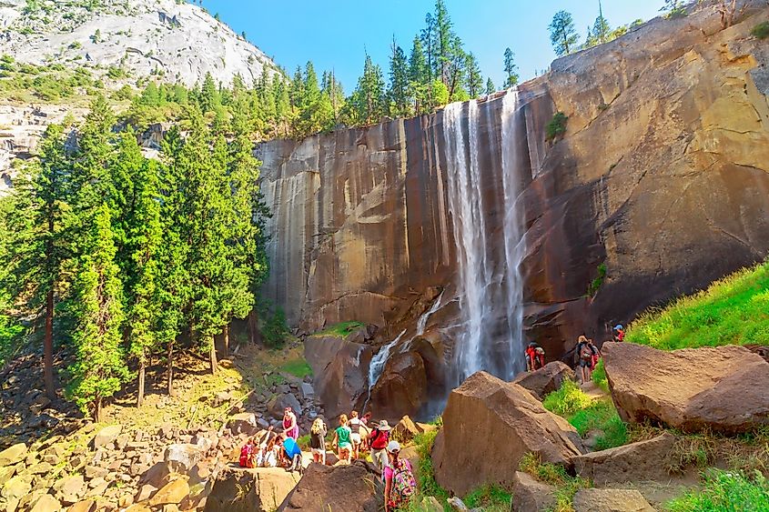 Hiking people in Yosemite National Park at Vernal Falls on Merced River Mist trail. Cheering happy hiker enjoying the beautiful waterfalls.