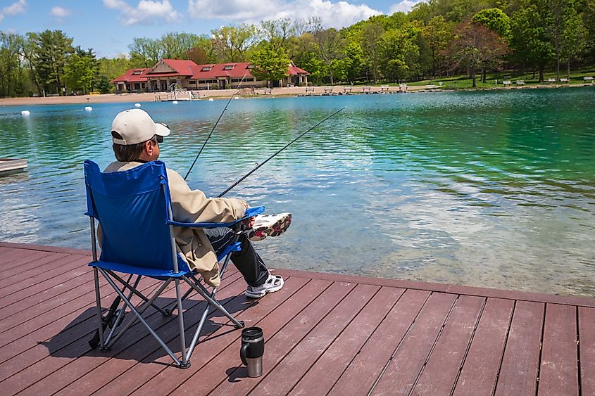 Fayetteville, NY USA - May 15, 2019: Man sitting oon dock at Green Lakes State Park.