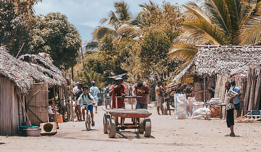 Madagaskarlı iki genç adam pazaryeri caddesinde bir vagonu itiyor. Madagaskar'da günlük yaşam