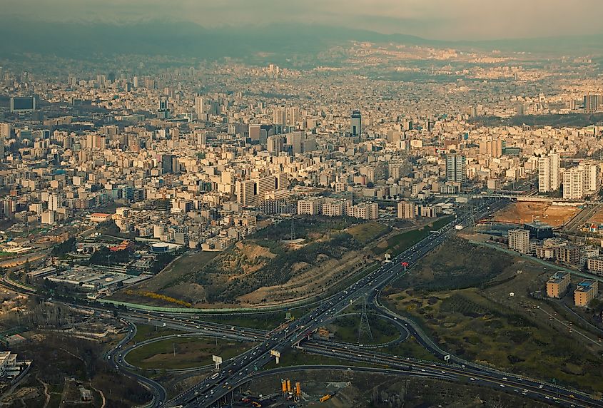 Aerial view of Tehran with sunlight breaking through clouds.