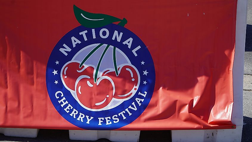 Logo for the National Cherry Festival in Grand Traverse City Hanging over a Barricade.