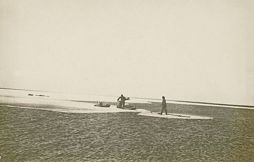 A black and white image of two men at Yathkyed Lake using Ice floes as Ferry boats. The date is 1924.