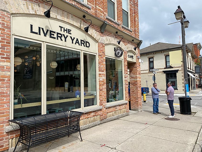 Two men chatting outside of a small town coffee shop called The Livery Yard.