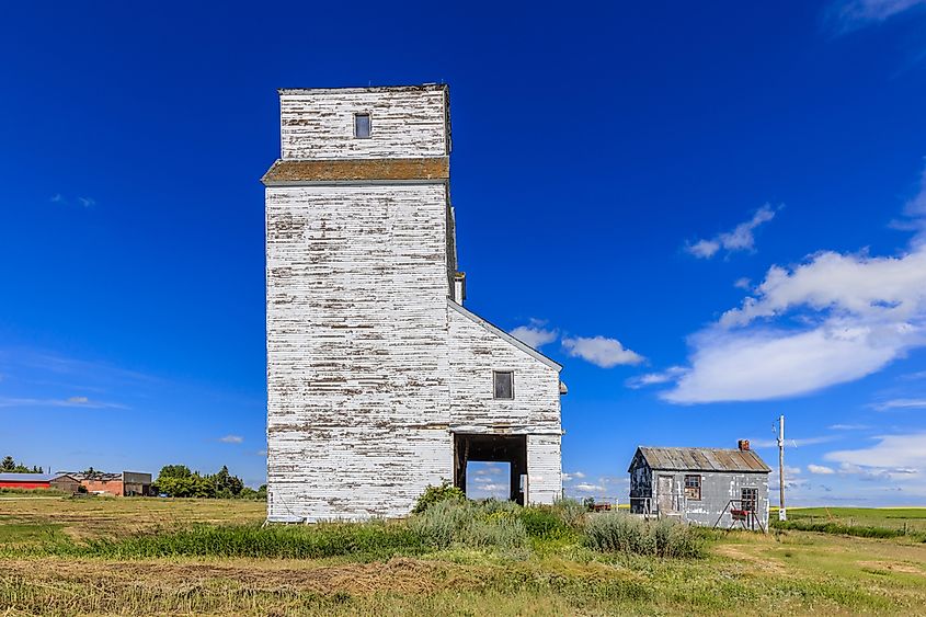 A grain elevator over farmland on the Canadian prairie.