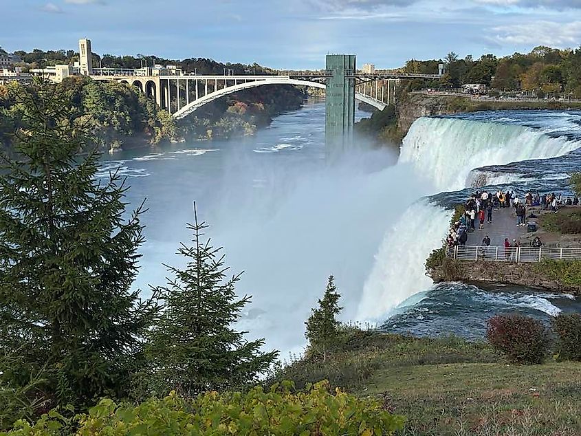 A crowd gathers atop a lookout to watch Niagara Falls roar over the edge.