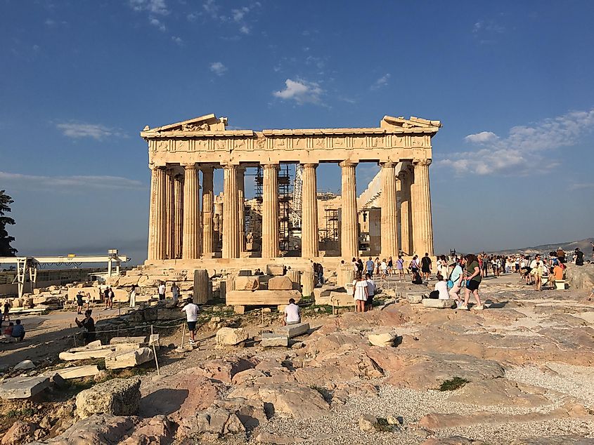 The iconic Parthenon, glowing in the sun in front of a clear blue sky. 