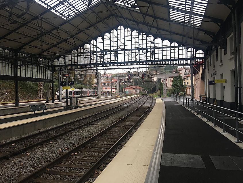 Empty tracks underneath an overhang at a French train station. 