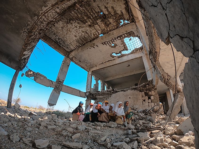 Yemeni children sit inside the rubble of their school, destroyed by the war in Taiz city , Yemen