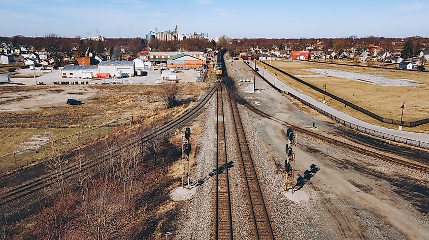 Freight train operated by CSX moving through the area with the cityscape of Fostoria, Ohio