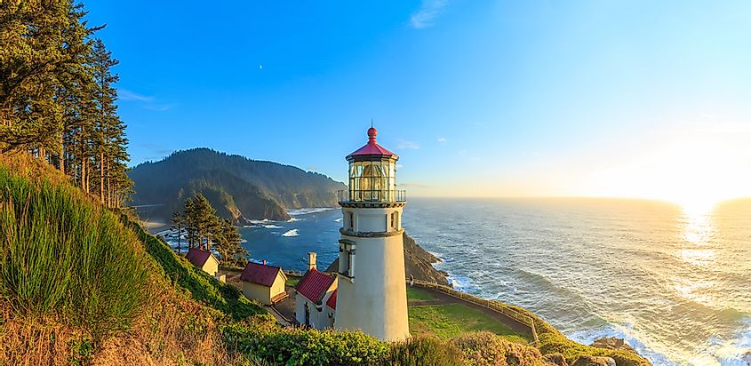The sun sets in the sea and illuminates Heceta Head Lighthouse, Oregon