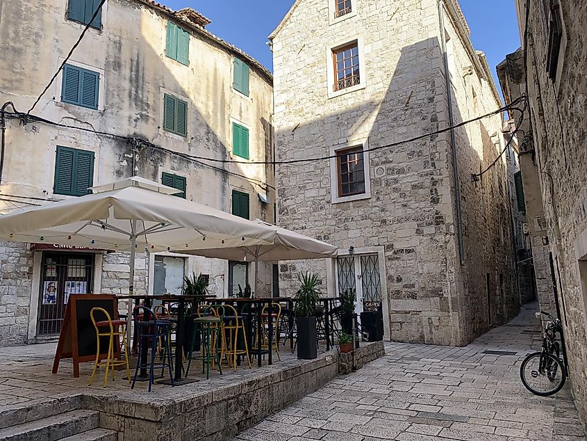 A cafe with colorful chairs fills out a quiet Old Town square in Split, Croatia