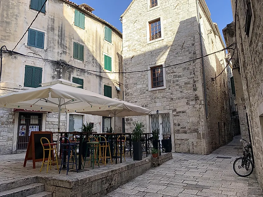 A cafe with colorful chairs fills out a quiet Old Town square in Split, Croatia