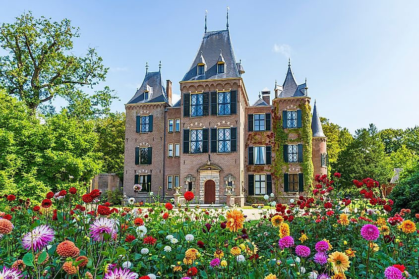 The front view of a beautiful castle with the colorful dahlias in the foreground in a park in Lisse, the Netherlands.