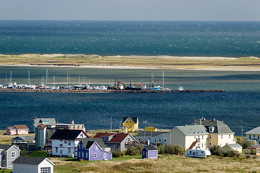 Houses, port and Sandy Hook dune at Havre-Aubert, Magdalen Islands. Photo via Wikimedia Commons