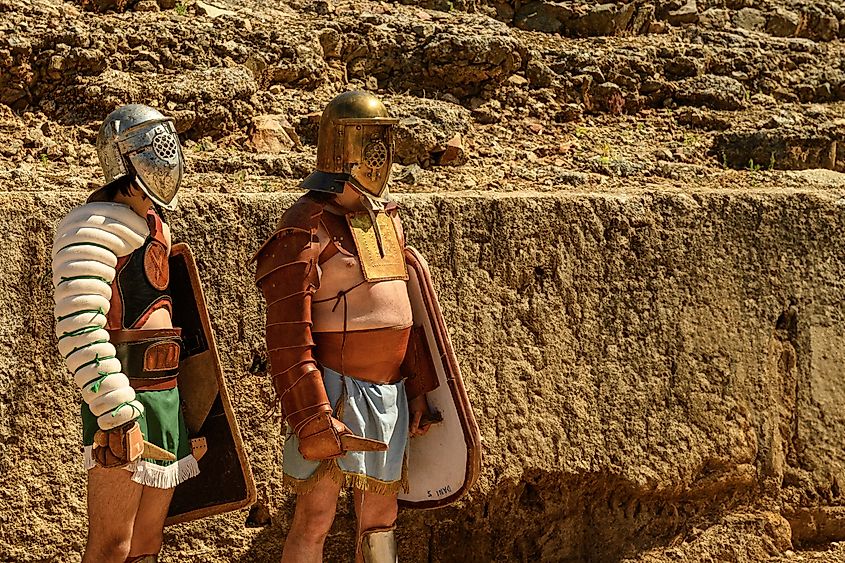 Two reenactors dressed as Roman gladiators stand in the ancient amphitheater in Merida, Spain.