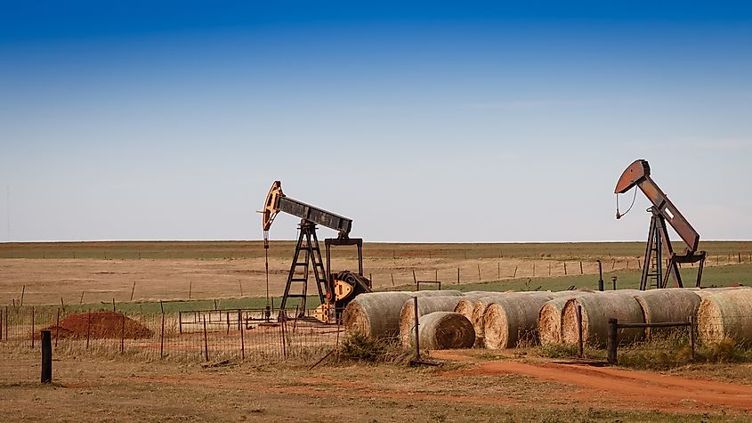 Hay bales and oil pumps on the prairie in rural Oklahoma.
