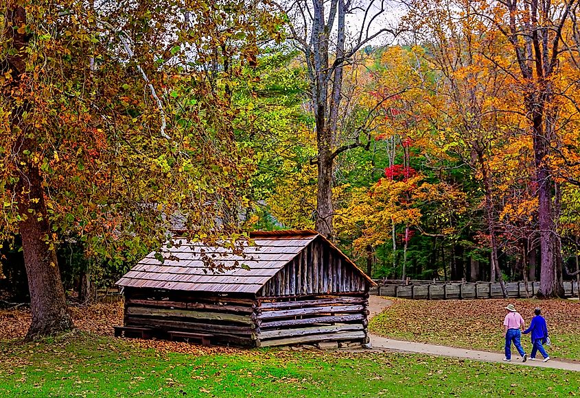 A couple walks down the path toward the blacksmith shop at the John P. Cable Mill Complex in Great Smoky Mountains National Park.