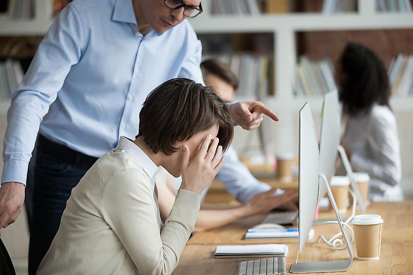 An angry manager shouting at a stressed employee