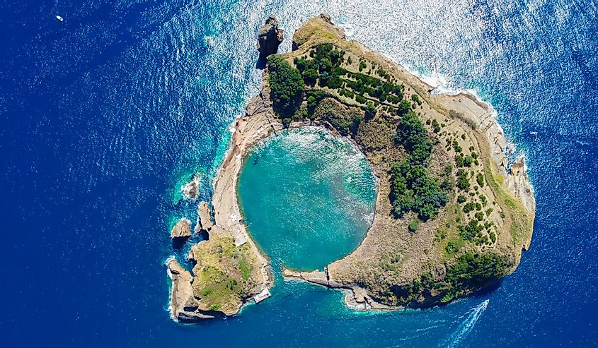 Aerial view of submerged volcano crater in the deep blue and azure Atlantic Ocean called Ilheu de Vila Franco do Campo which is part of the Azores on Sao Miguel Island, Portugal.