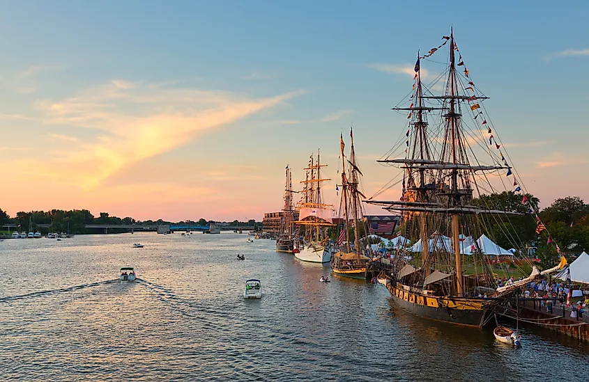 Tall ships line the river's edge at Wenonah Park in Bay City, Michigan, during the Tall Ship Celebration at sunset.