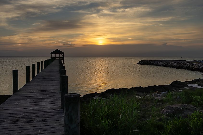 The sun sinks behind a cloud on the sound side of Salvo, North Carolina in the Cape Hatteras National Seashore. Credit: Tracey Mershon/Shutterstock.com