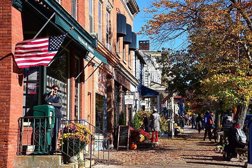 A sidewalk in Cold Spring, New York lined with buildings and people.