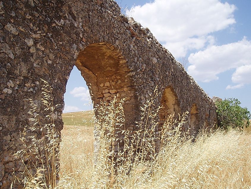 An ancient Roman aqueduct in a grain field near Rome, Italy.