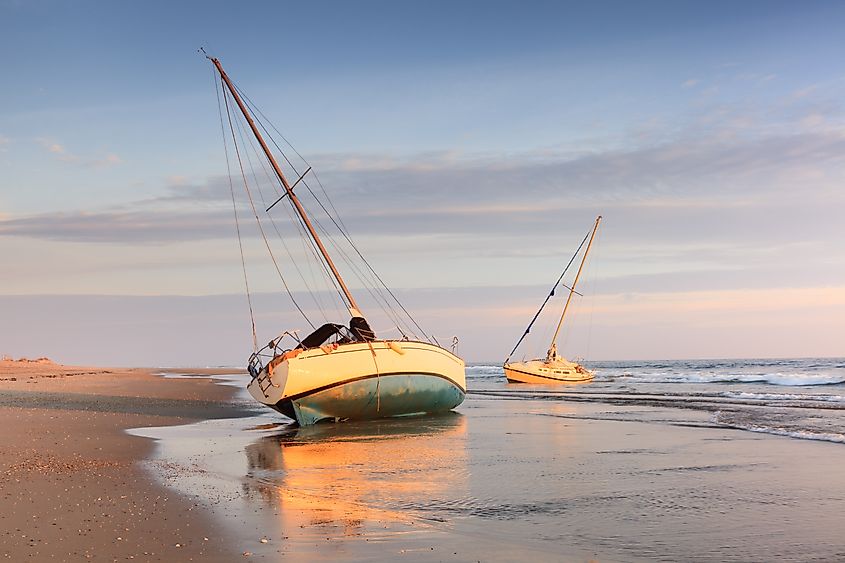 Two shipwrecked sailing boats beached on the Cape Hatteras National Seashore on the Outer Banks of North Carolina. Credit: Cvandyk/Shutterstock.com