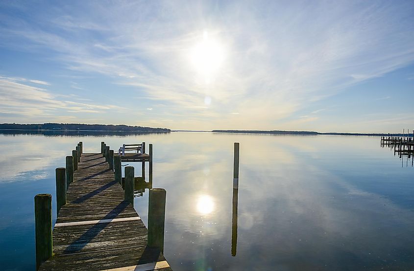 A pier juts into the mirror-like waters of Breton Bay, in Leonardtown, Maryland.
