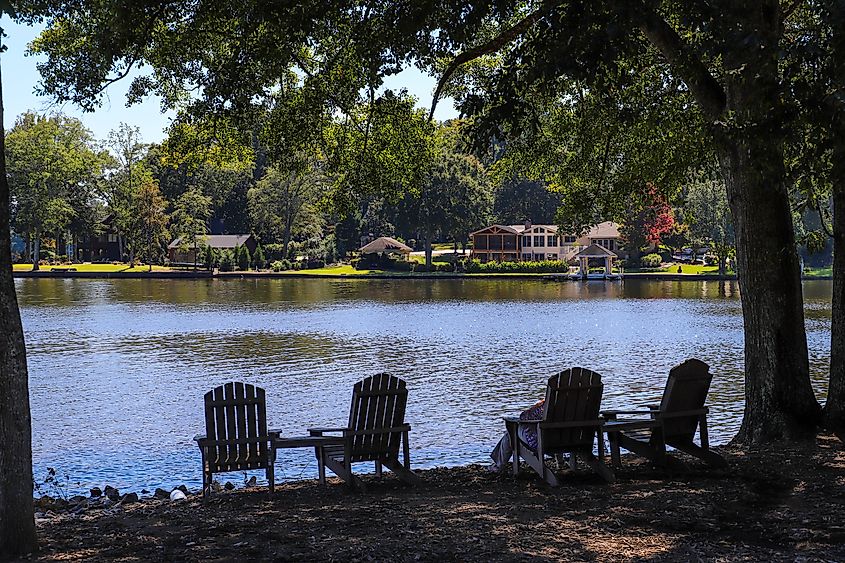 People relaxing in lawn chairs on the grassy banks of Lake Peachtree in Peachtree City, Georgia