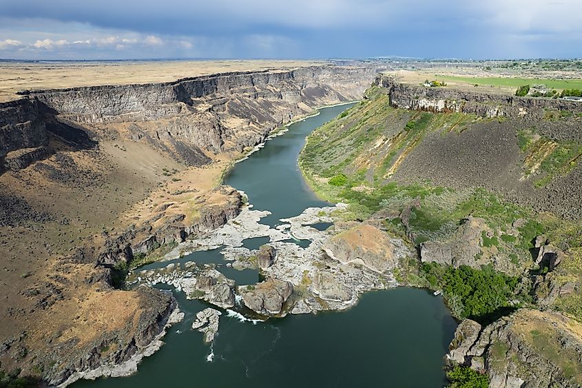 Aerial view of the Snake River canyon with the snake river and surrounding green grassland. Shot near the Perrine Memorial Bridge in Twin Falls, Idaho state, USA.