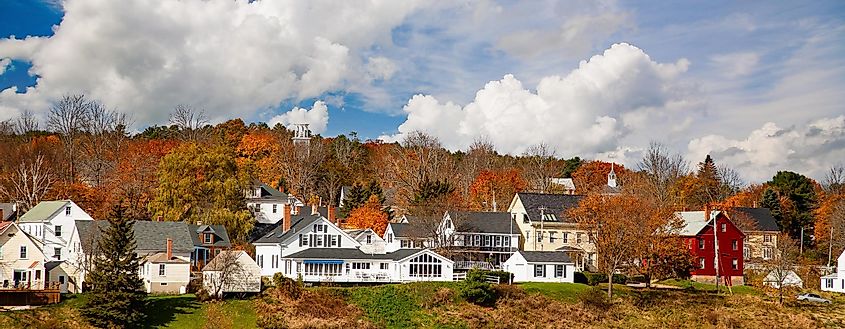 Waterfront homes surrounded by fall colors in Wiscasset, Maine, USA.