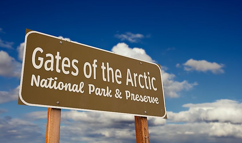 Road sign for Gates of the Arctic National Park and Preserve in Alaska against a blue sky with clouds