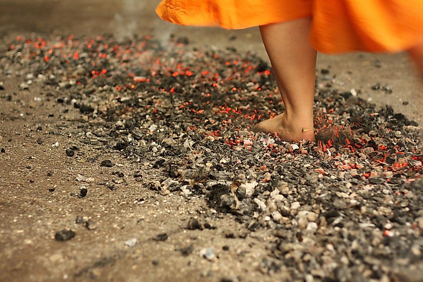 A barefoot participant walks across a bed of glowing coals during a fire-walking ritual