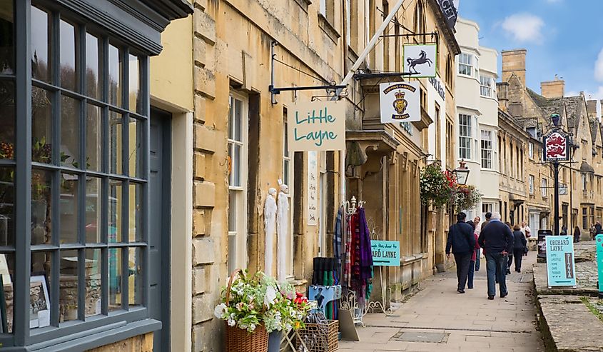 Quaint stone buildings along the street in Cotswolds in English countryside.