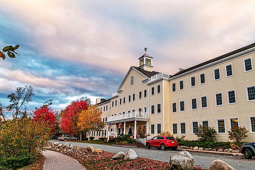 Littleton, New Hampshire, in autumn. White building with a red car parked out front.