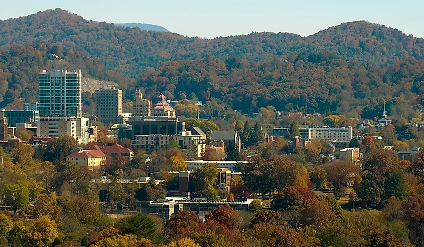 Aerial view of Asheville city in North Carolina with high buildings and mountain hills in distance